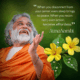 AtmaNambi spiritual master in orange robes with yellow flowers teaching that staying connected to your center brings peace and effortless action in daily life.