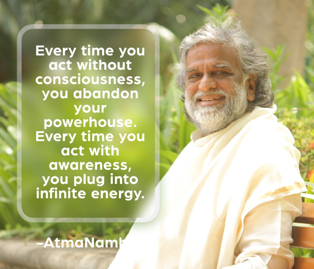 AtmaNambi spiritual quote poster showing the enlightened Indian master in white robes seated outdoors amidst greenery, sharing his teaching that acting with awareness plugs you into infinite energy while unconscious action abandons your inner powerhouse.