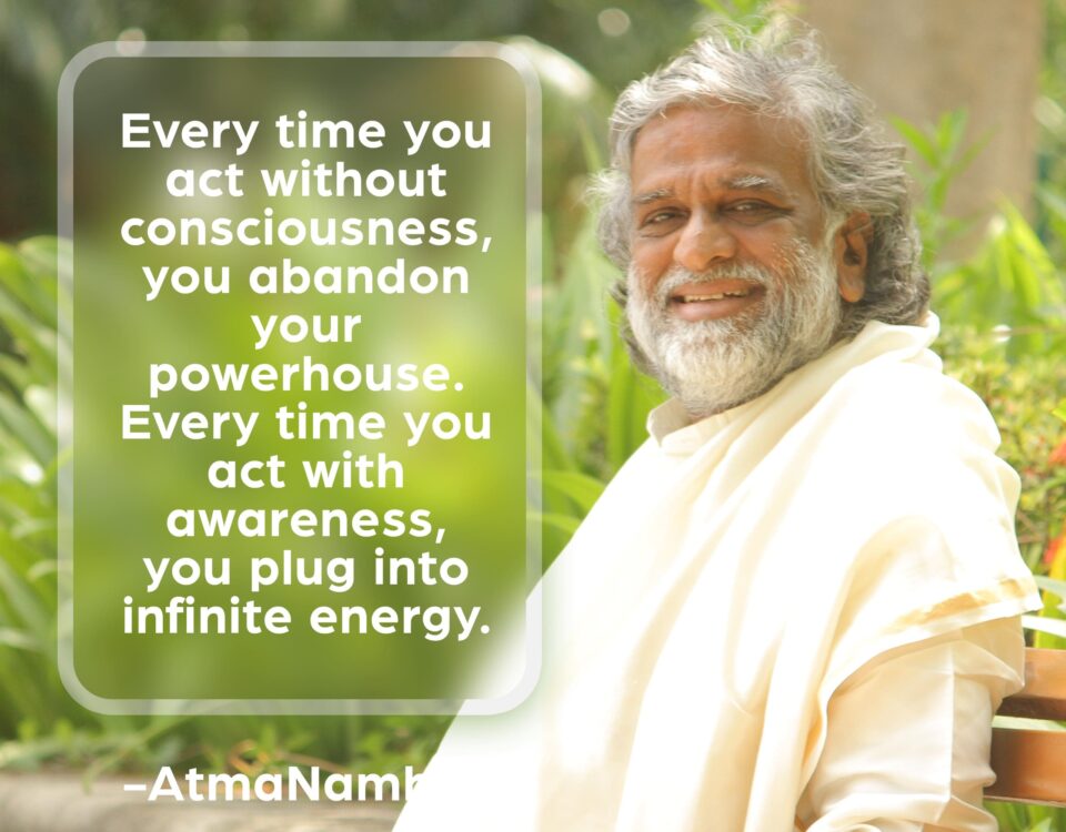 AtmaNambi spiritual quote poster showing the enlightened Indian master in white robes seated outdoors amidst greenery, sharing his teaching that acting with awareness plugs you into infinite energy while unconscious action abandons your inner powerhouse.