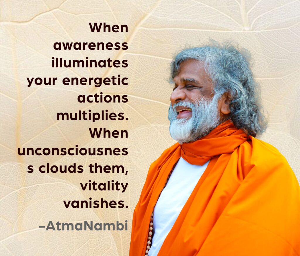 AtmaNambi, Indian enlightened master in saffron robes smiling radiantly, sharing his awareness multiplies energy spiritual teaching on how consciousness amplifies vitality and unconsciousness diminishes it.