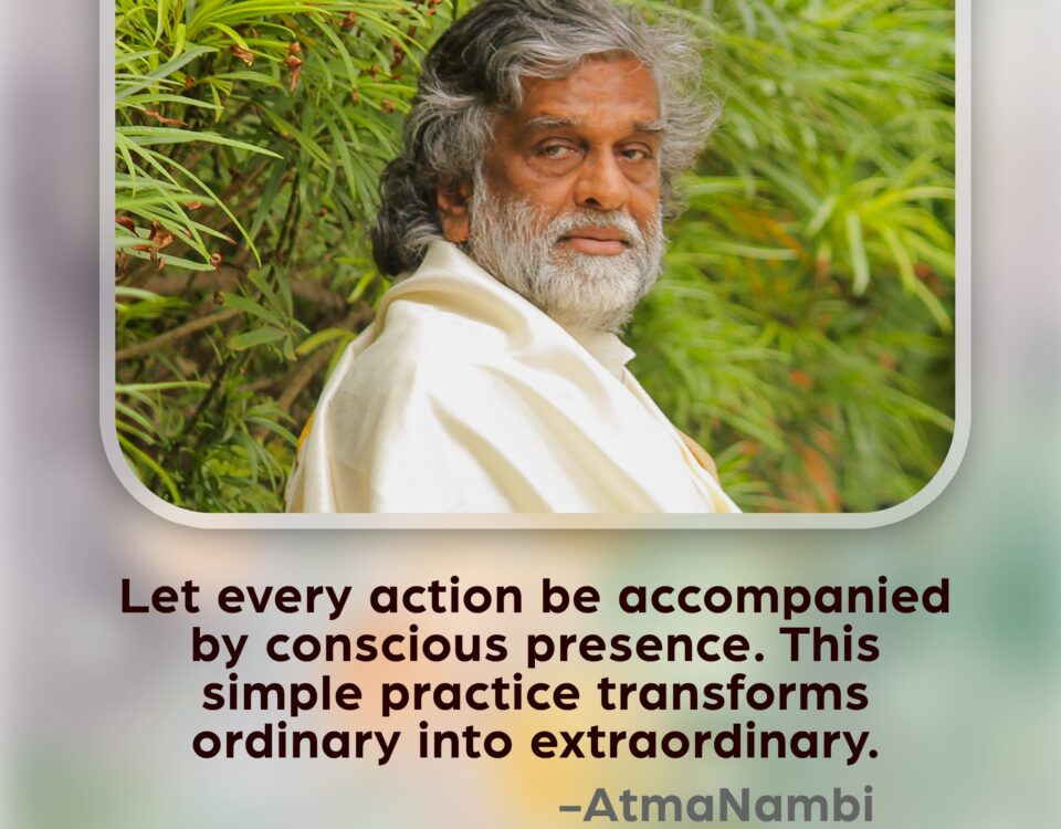 AtmaNambi, Indian enlightened master in white robes seated amid lush greenery with a deeply aware gaze, sharing his conscious presence spiritual teaching that transforms ordinary actions into extraordinary ones.