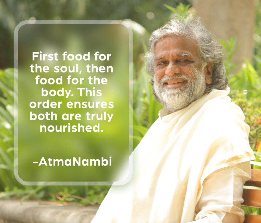 AtmaNambi seated serenely outdoors, sharing his teaching on nourishing soul and body — that feeding the inner life first ensures both are truly sustained.